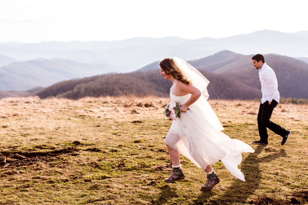 bride running in front of the groom on a mountain top
