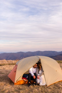 newly wed couple in a tent on a mountain top